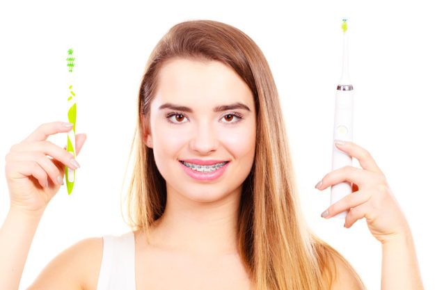 types of toothbrushes (3) girl holding types of toothbrushes