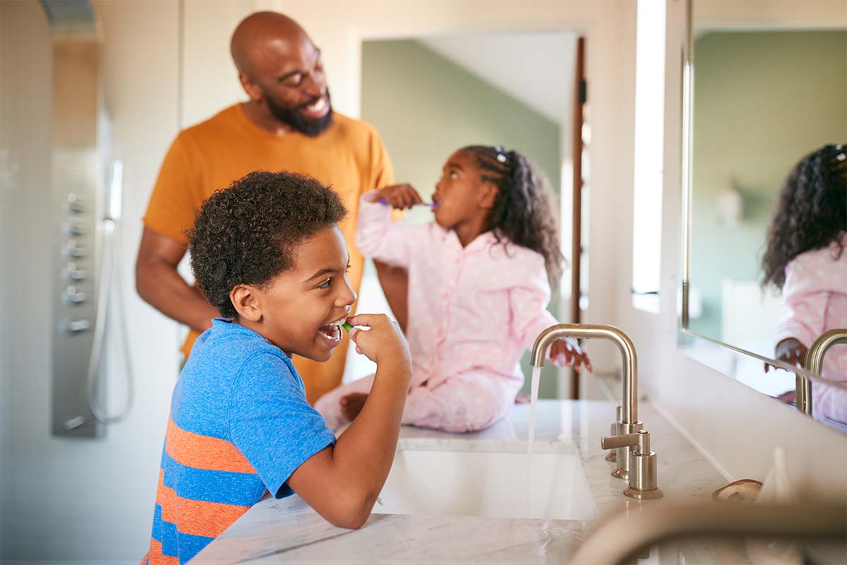 healthy-smile-tips Father Helping Kids Brush Their Teeth