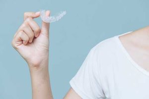 person holding clear aligners